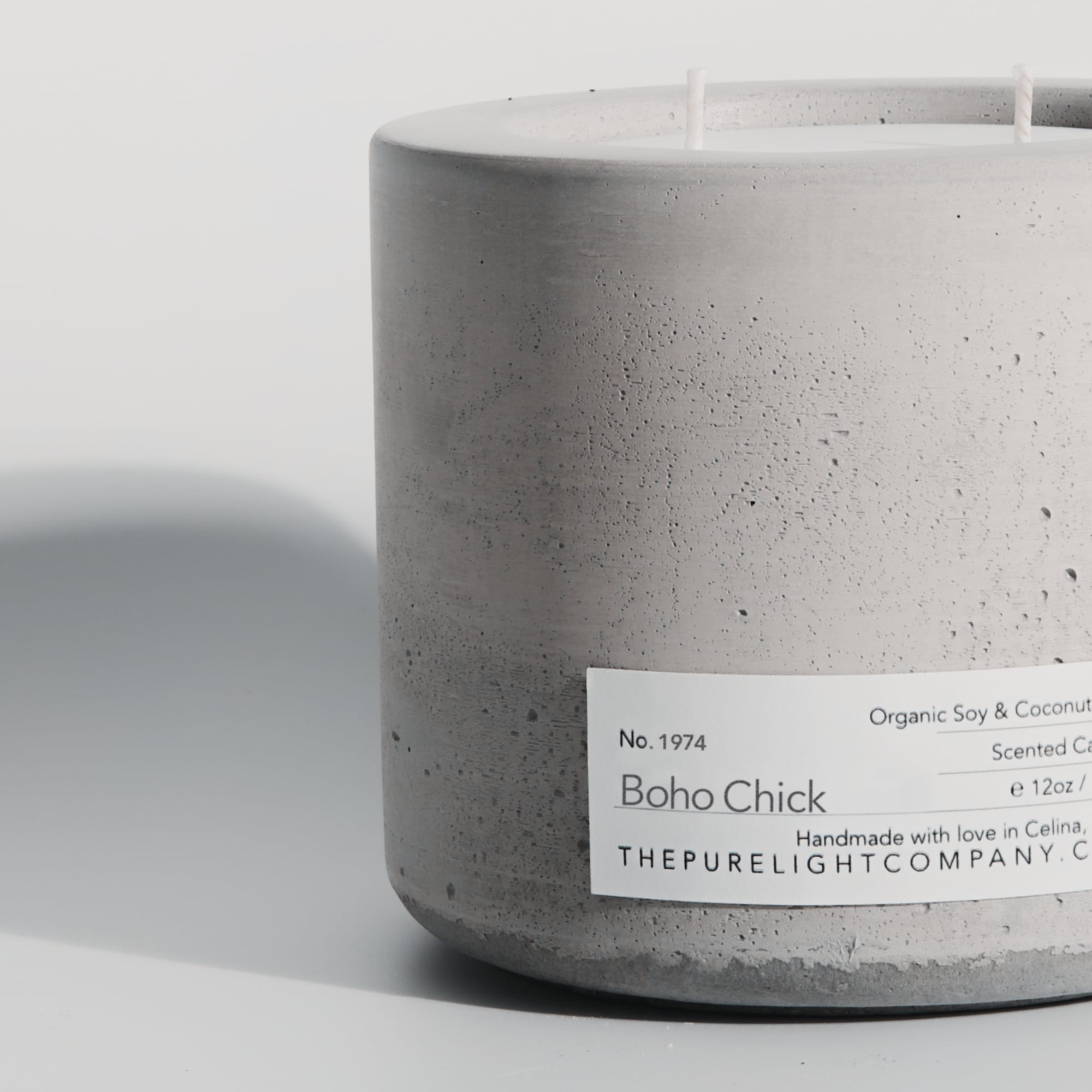 Close-up of the Large Boho Chick gray concrete candle in a lifestyle setting with soft shadow, by The Pure Light Company