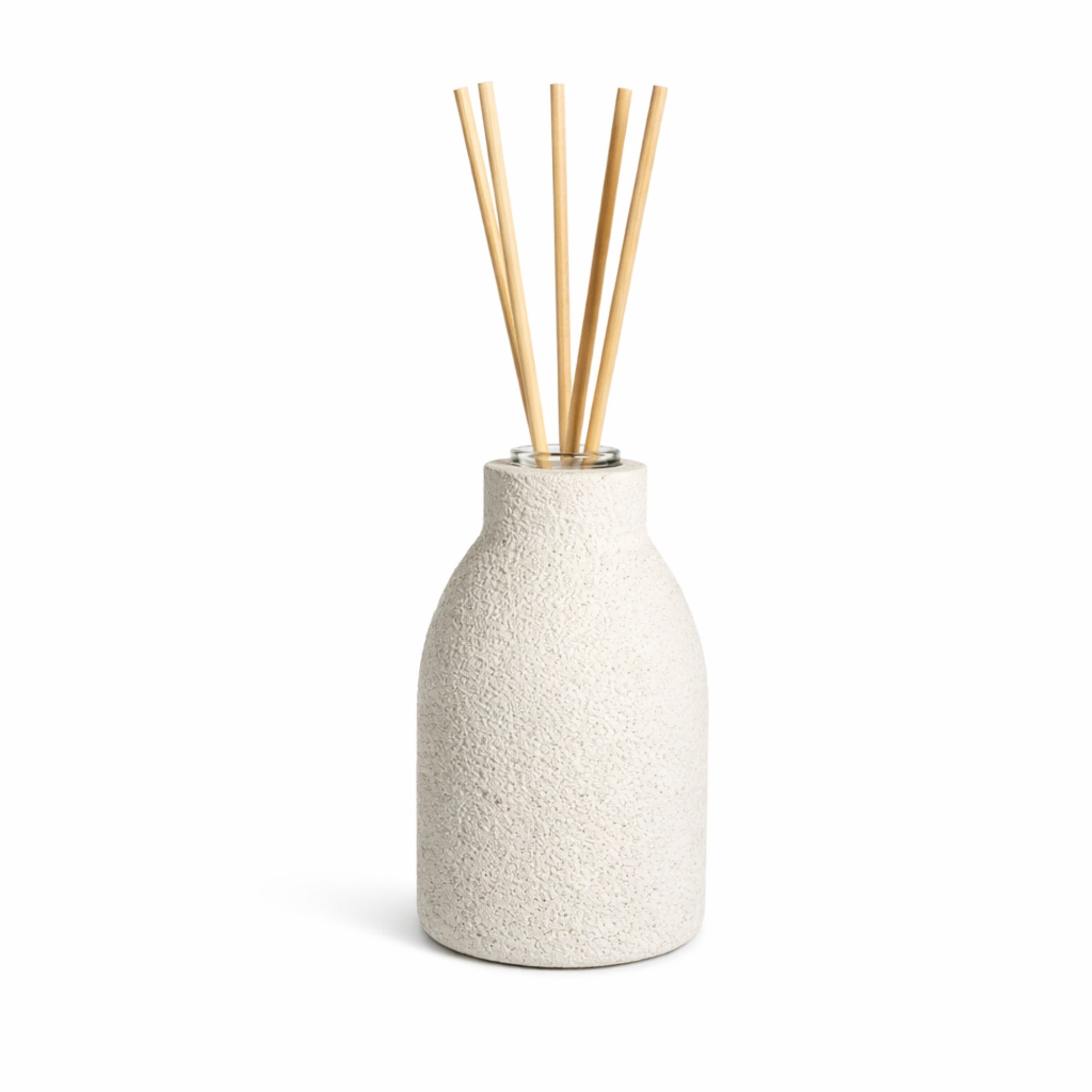Textured white concrete diffuser with wooden reeds on a white background