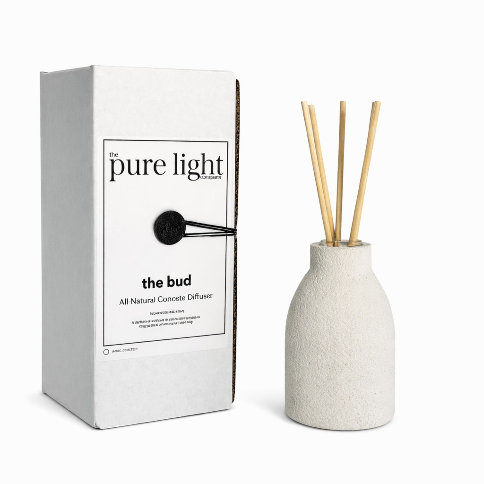 White concrete diffuser with wooden reeds next to its packaging labeled 'the pure light company'.
