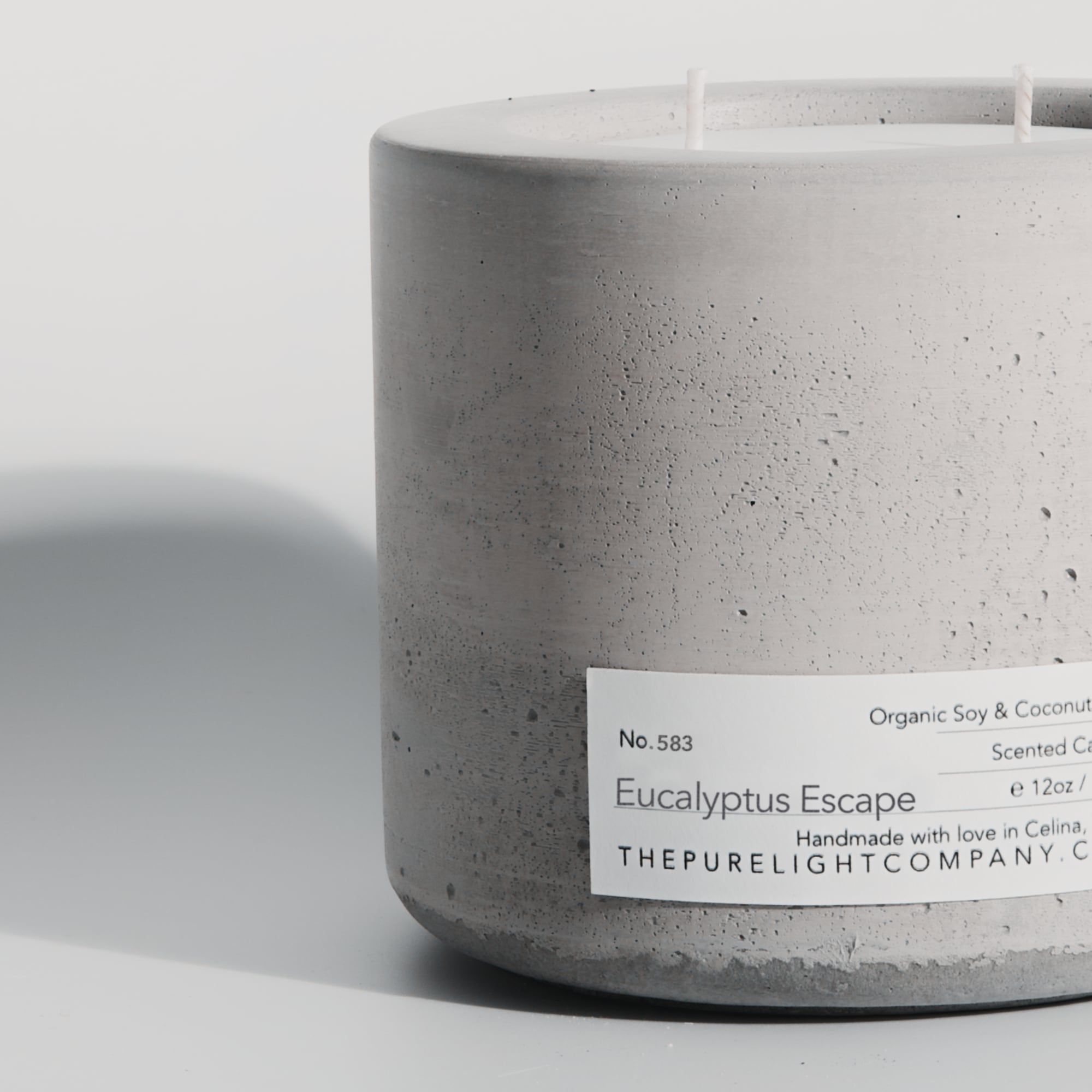Close-up of the Large Eucalyptus Escape gray concrete candle in a lifestyle setting with soft shadow, by The Pure Light Company