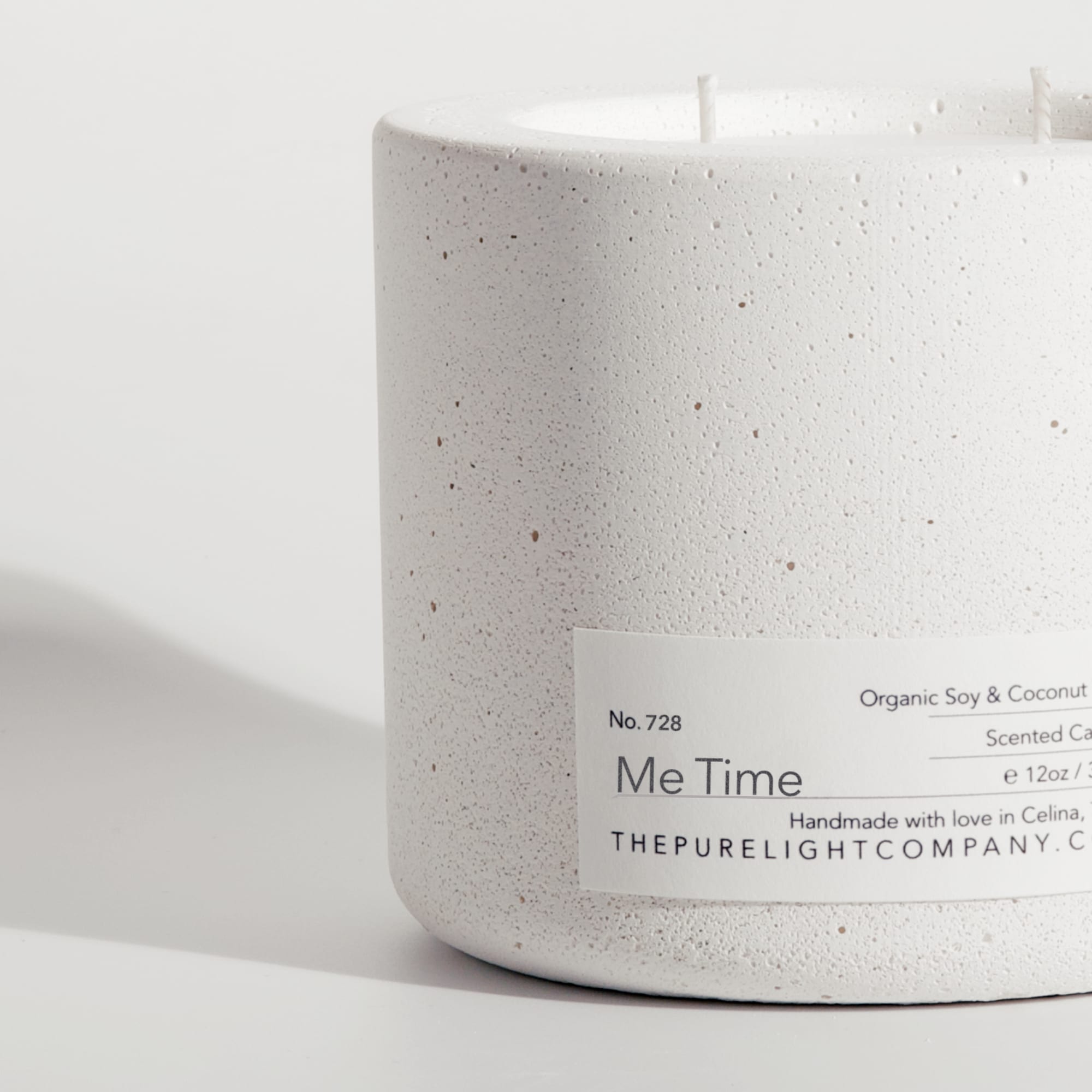 Close-up of the Large Me Time white concrete candle in a lifestyle setting with soft shadow, by The Pure Light Company