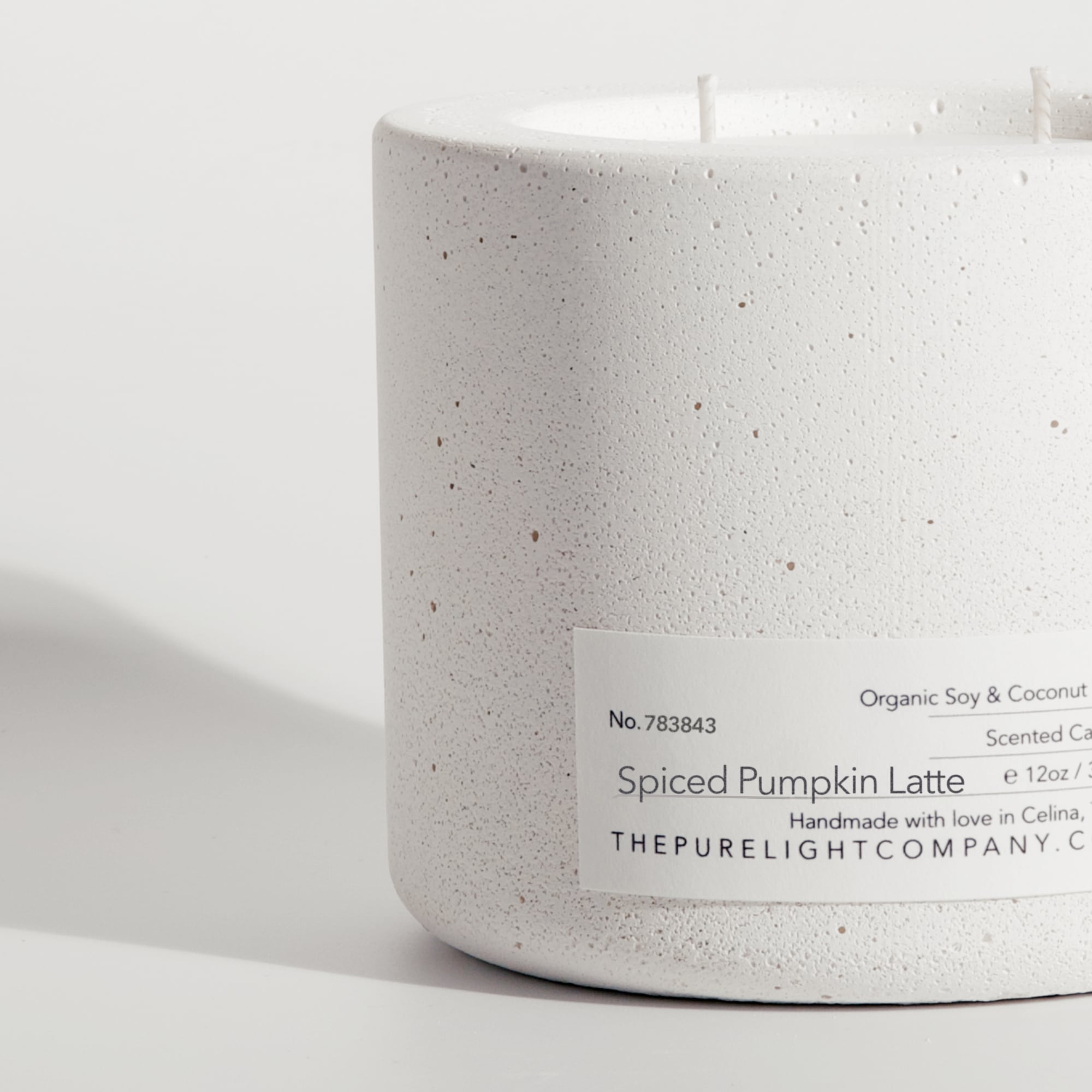 Close-up of the Large Spiced Pumpkin Latte black concrete candle in a lifestyle setting with soft shadow, by The Pure Light Company