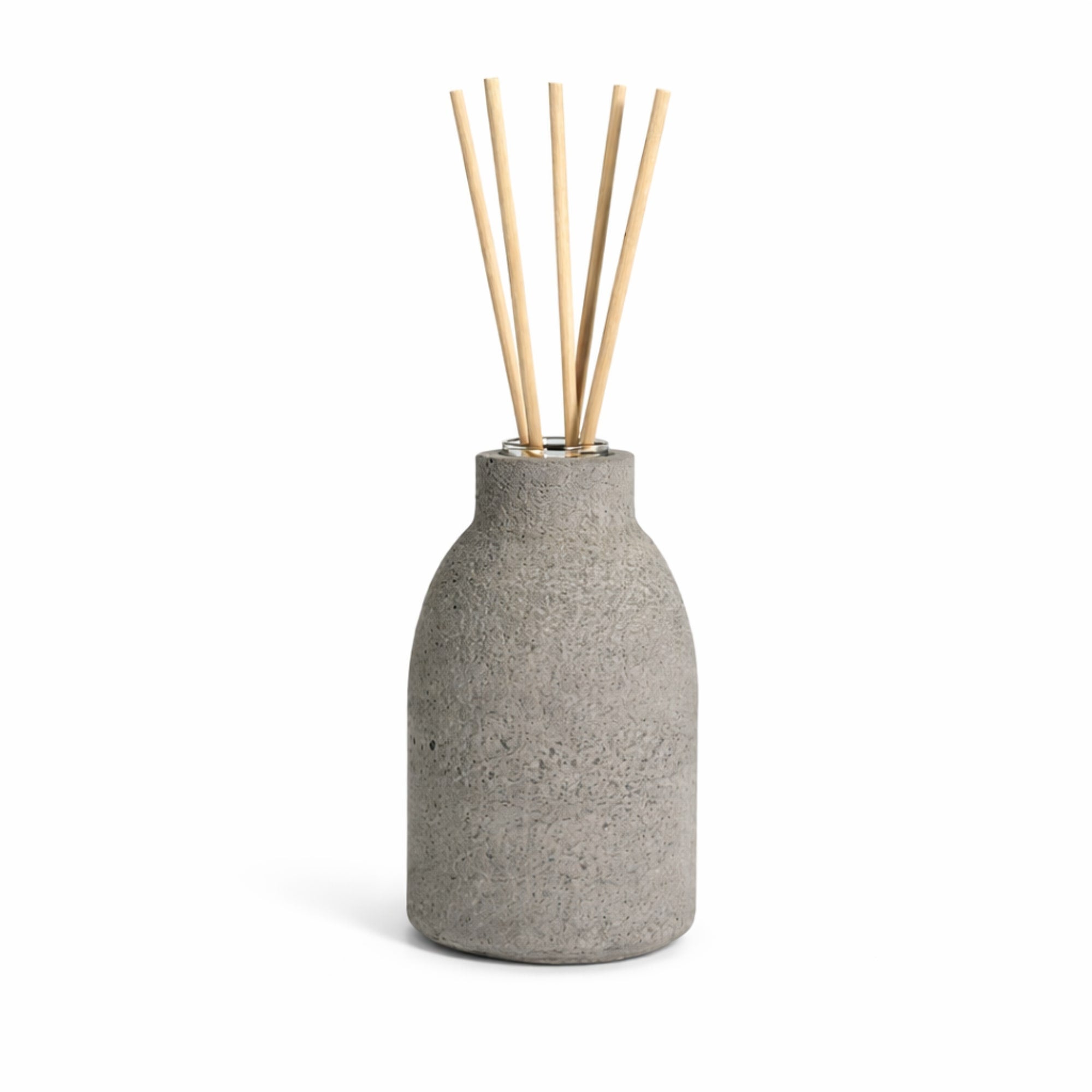 Gray concrete diffuser with five natural diffuser reeds on a white background
