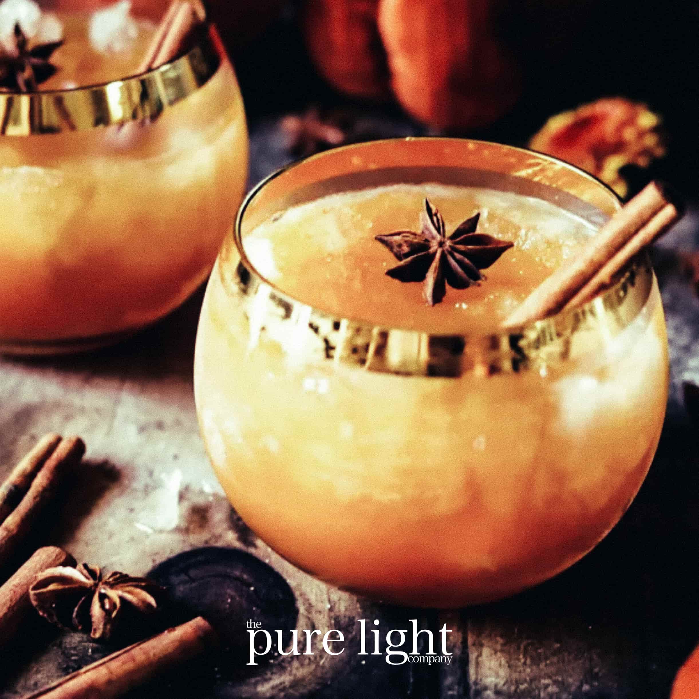 A boozy pumpkin cocktail with a cinnamon stick and a star anise used for the aesthetic of The Pure Light Company all-natural home fragrance collection. 