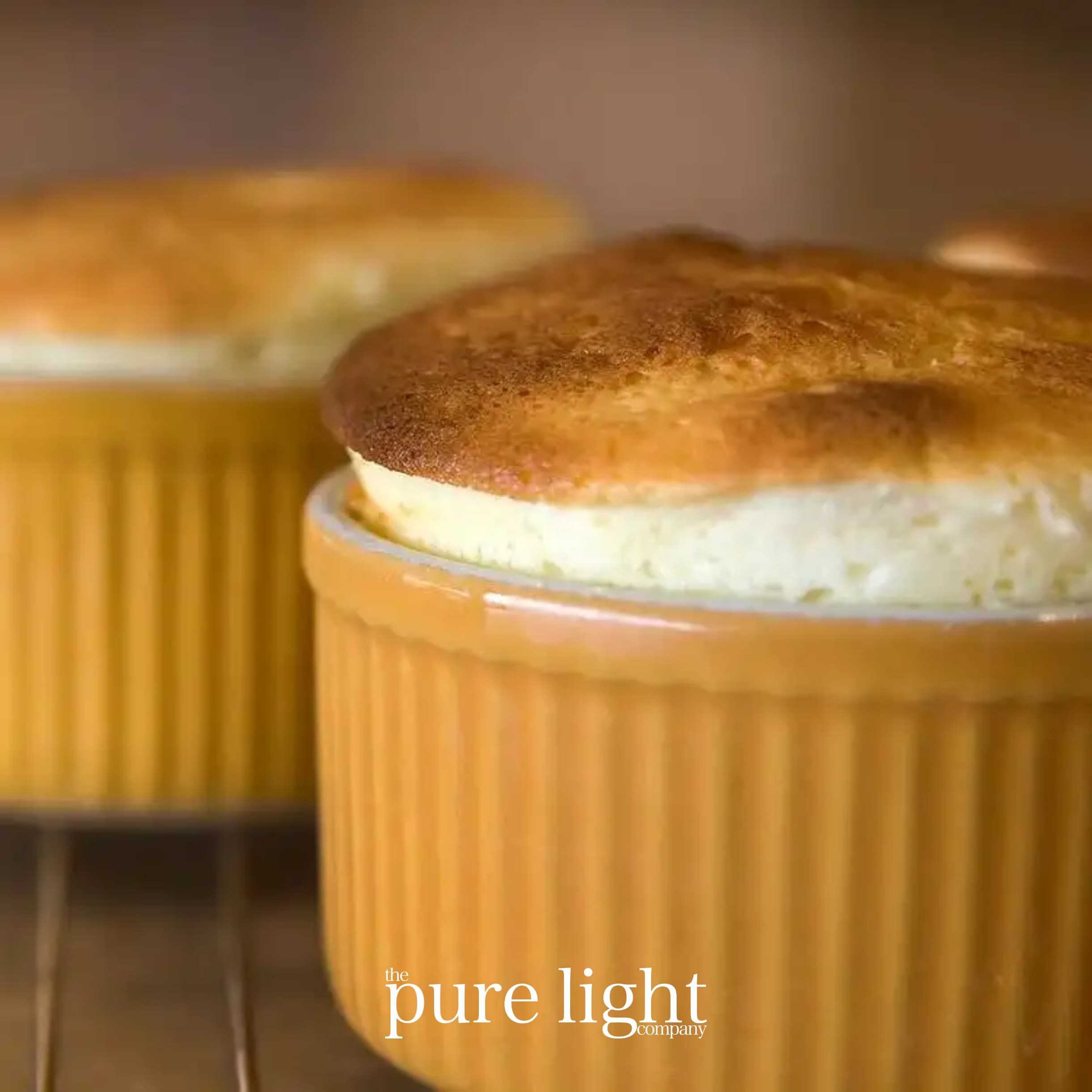 An image of two individual pumpkin soufflés in ramekins with The Pure Light Company logo