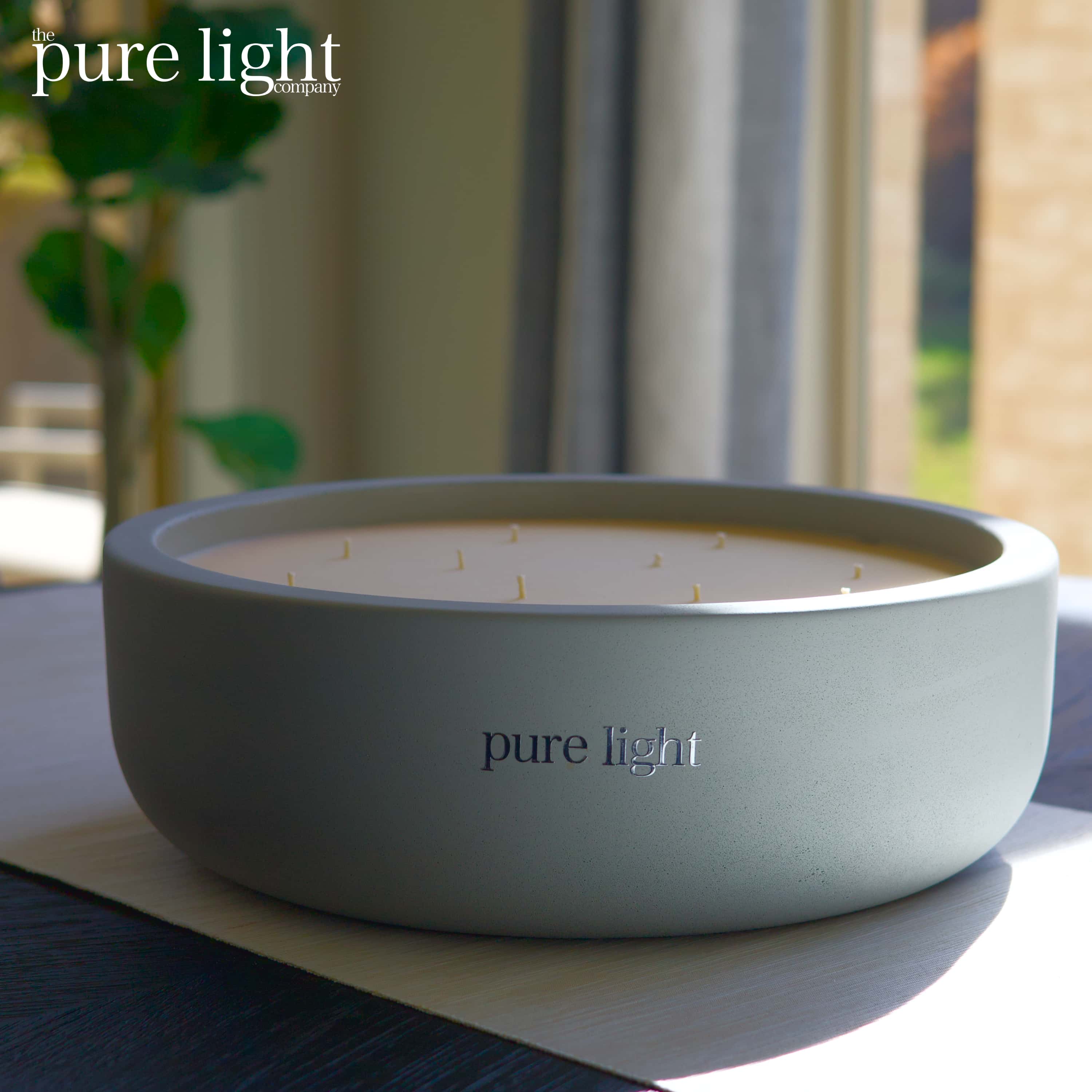 A huge, round Shampure Aveda Dupe concrete candle with 19 wicks, with The Pure Light Company logo.