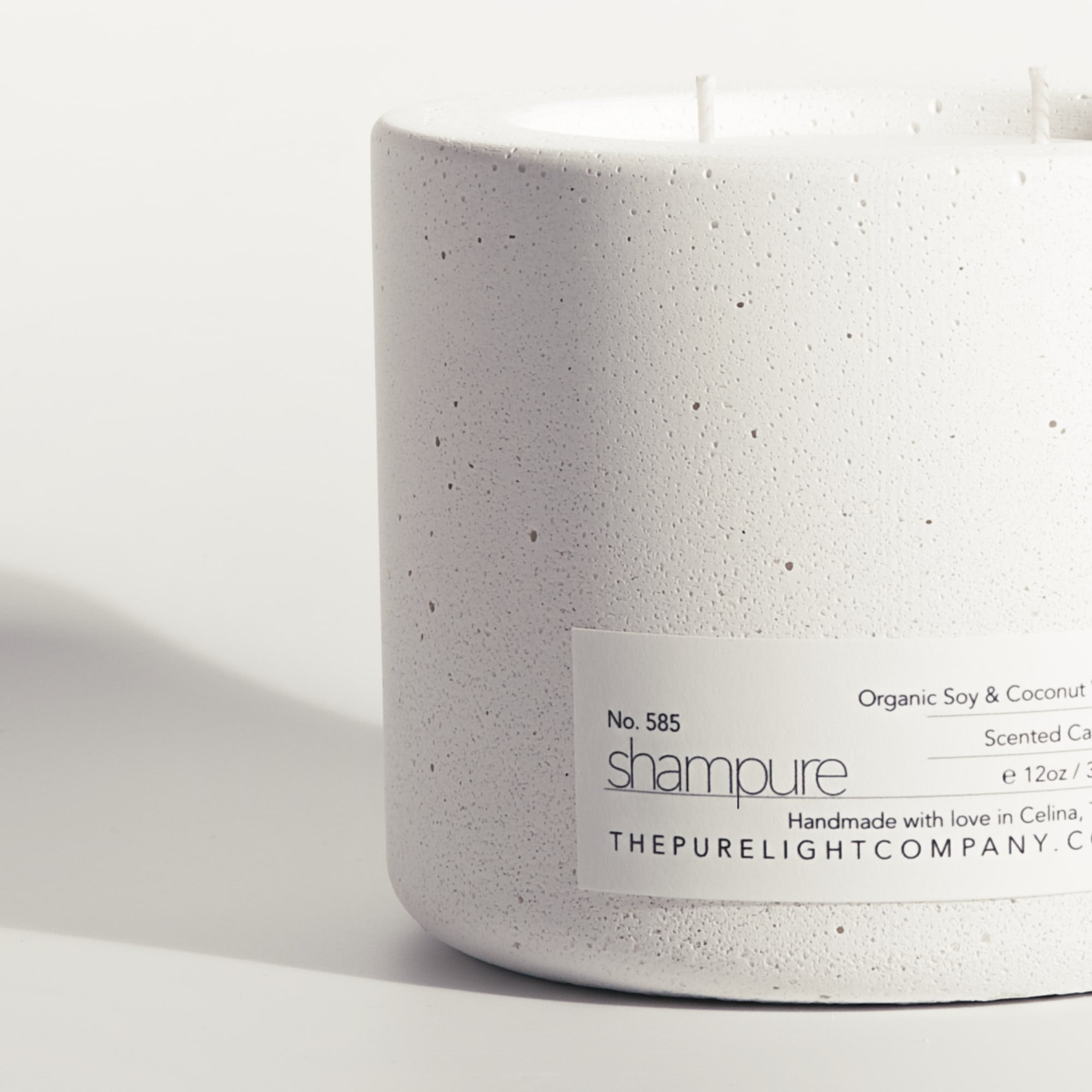 Close-up of the Large Shampure Aveda Dupe white concrete candle in a lifestyle setting with soft shadow, by The Pure Light Company