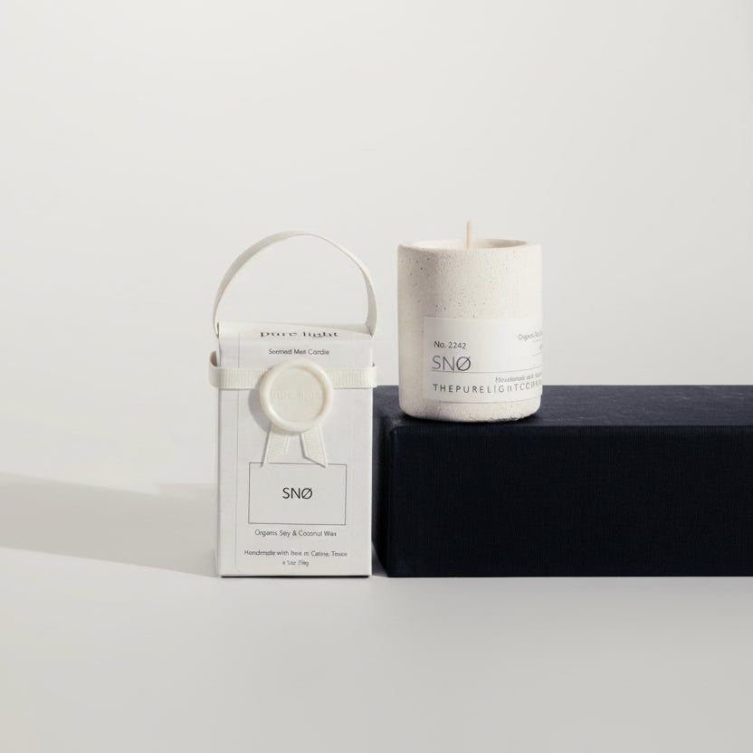 White concrete candle to its packaging with a white ribbon on a white background