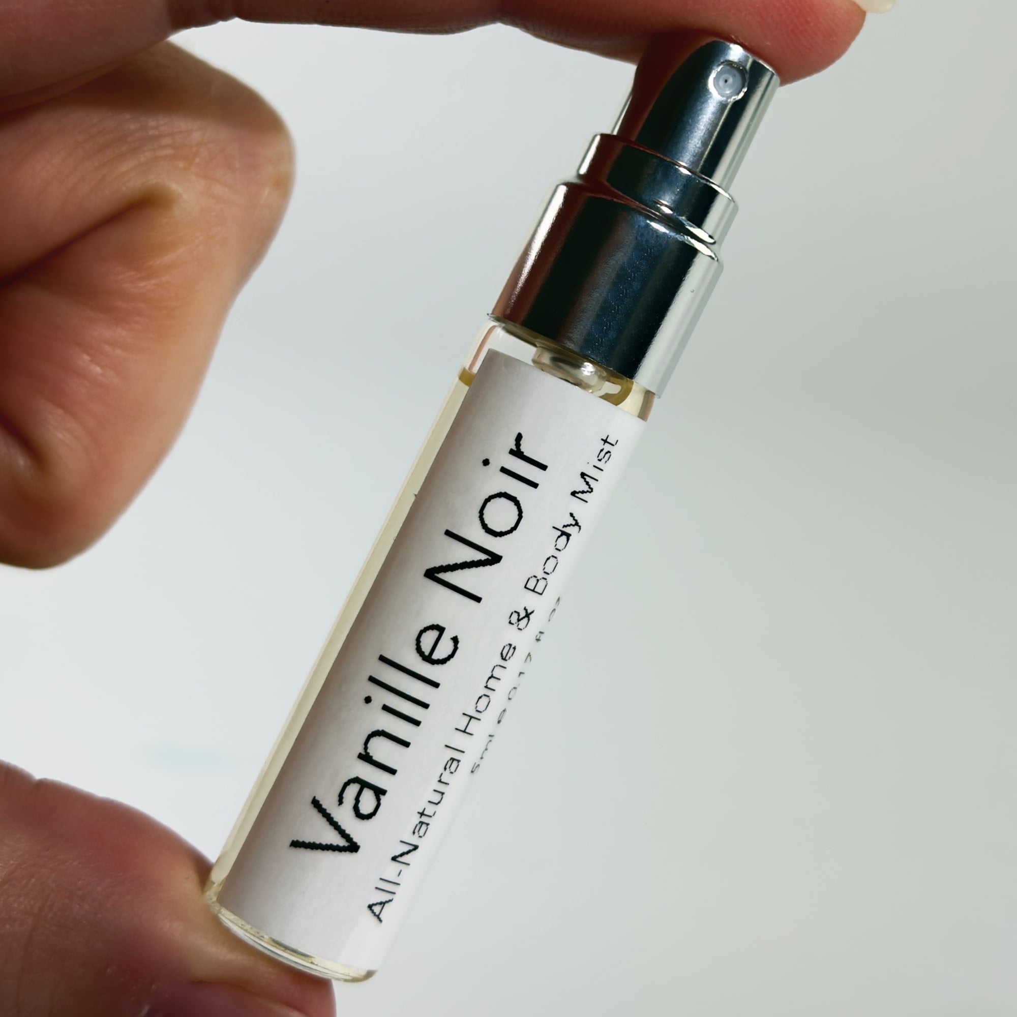 Vanille Noir 5ml All Natural Home & Body mist held by a hand on a white background